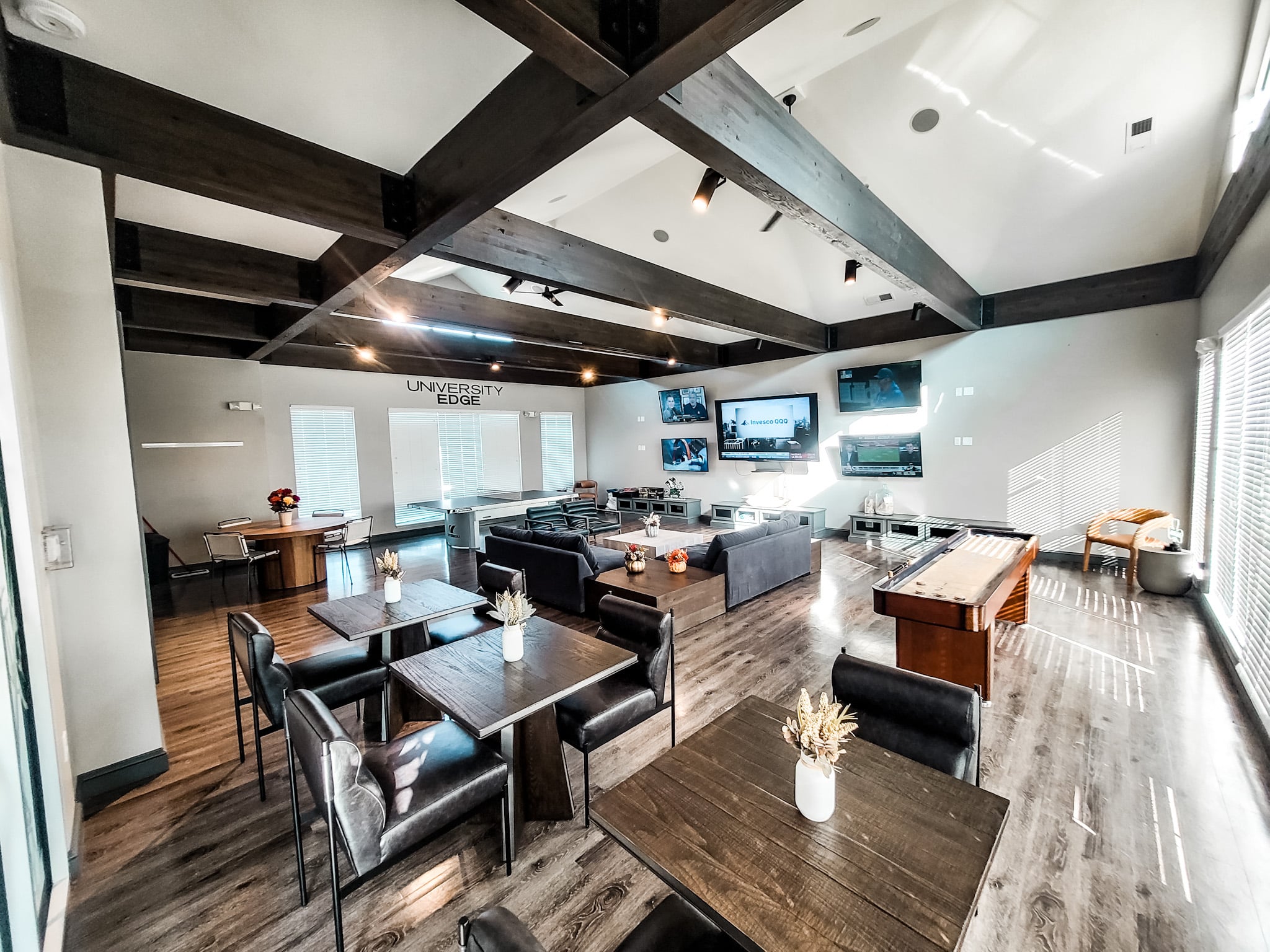 Resident clubhouse with lounge seating, TVs and shuffleboard at University Edge in South Bend
